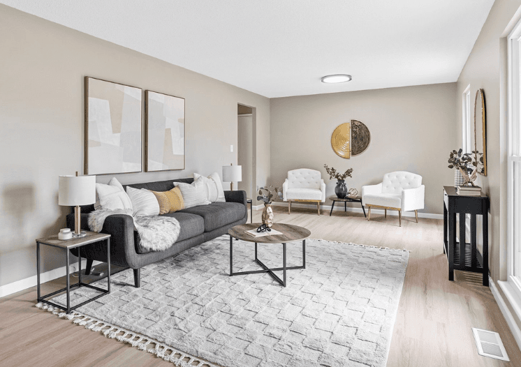 Living room after — warm neutral walls, new hardwood floors